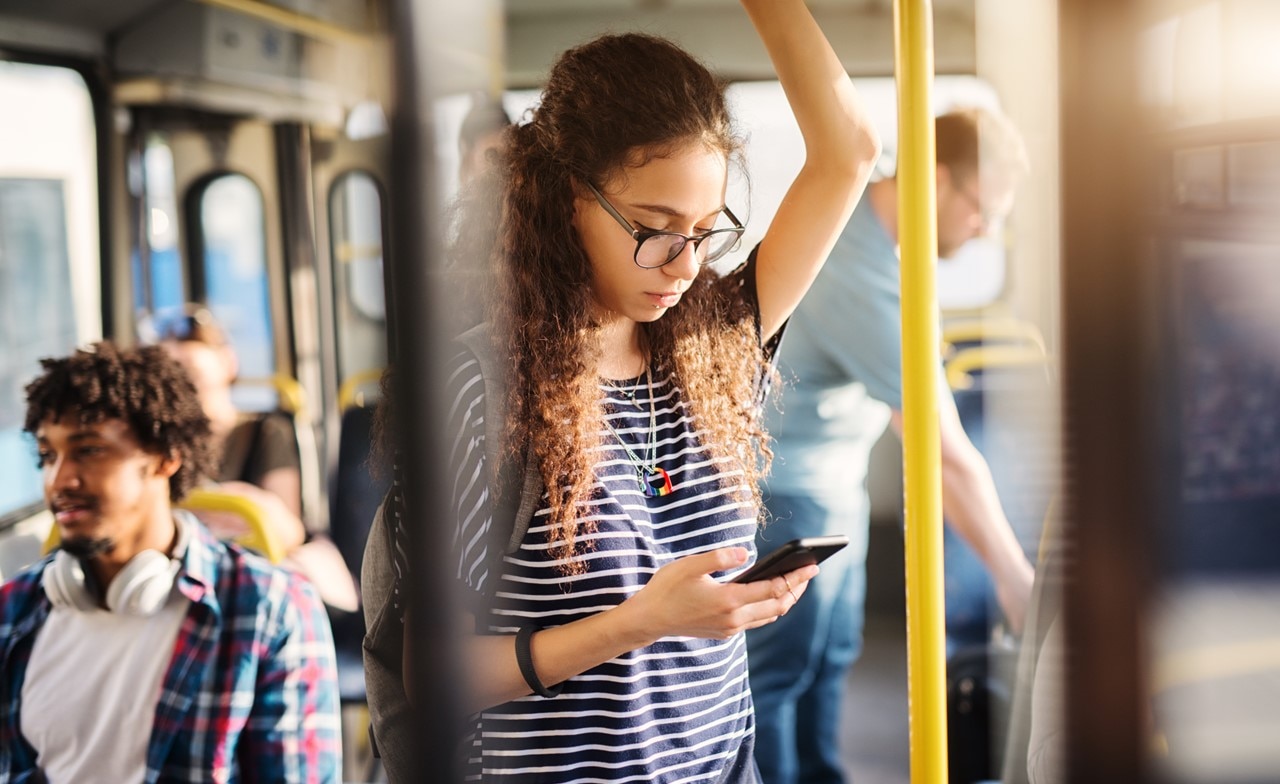 Girl looking at her phone in public transport Girl looking at her phone in public transport
