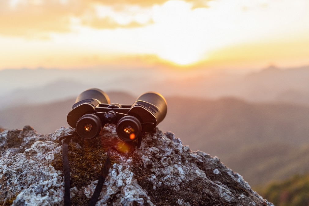 binoculars on top of rock mountain at sunset binoculars on top of rock mountain at sunset