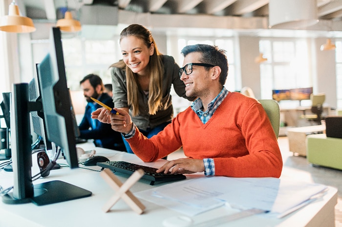 two coworkers looking at a computer screen 