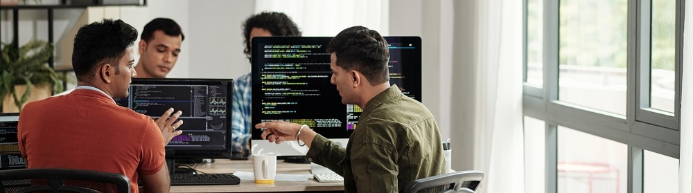 business-critical-operations Operations team working on computers at conference table