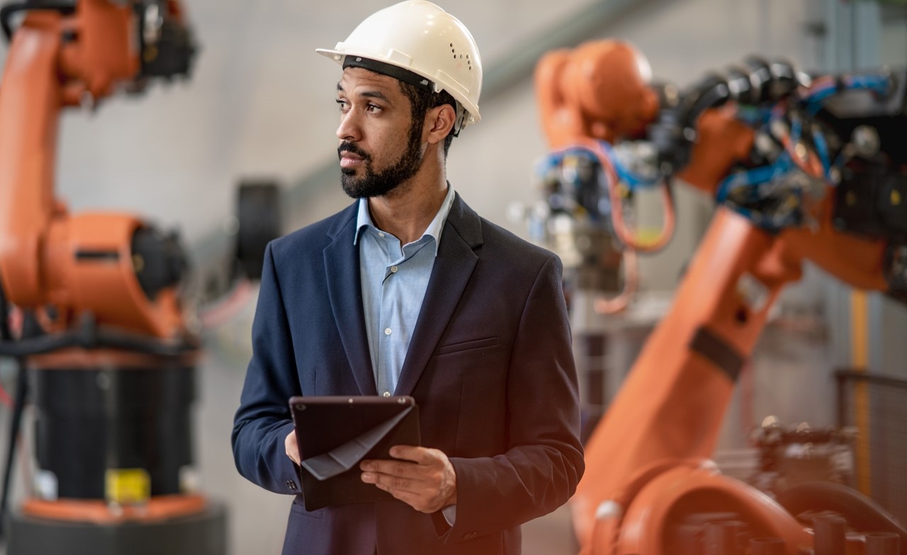 Engineer wearing a hardhat holding a tablet Engineer wearing a hardhat holding a tablet