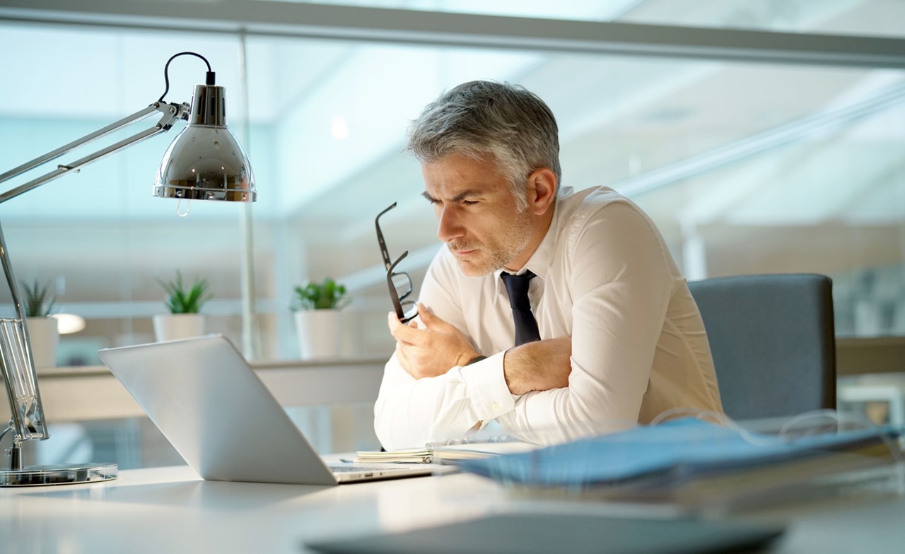 Executive overseeing corporate transaction banking on a laptop Executive overseeing corporate transaction banking on a laptop