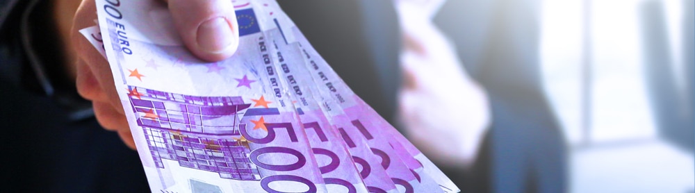 CGI Trade360 Cash Management Mann zeigt viel Geld in die Kamera und steckt sich weiteres Geld in Jackentasche