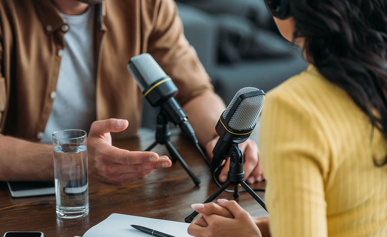 Two people taping a podcast Two people taping a podcast