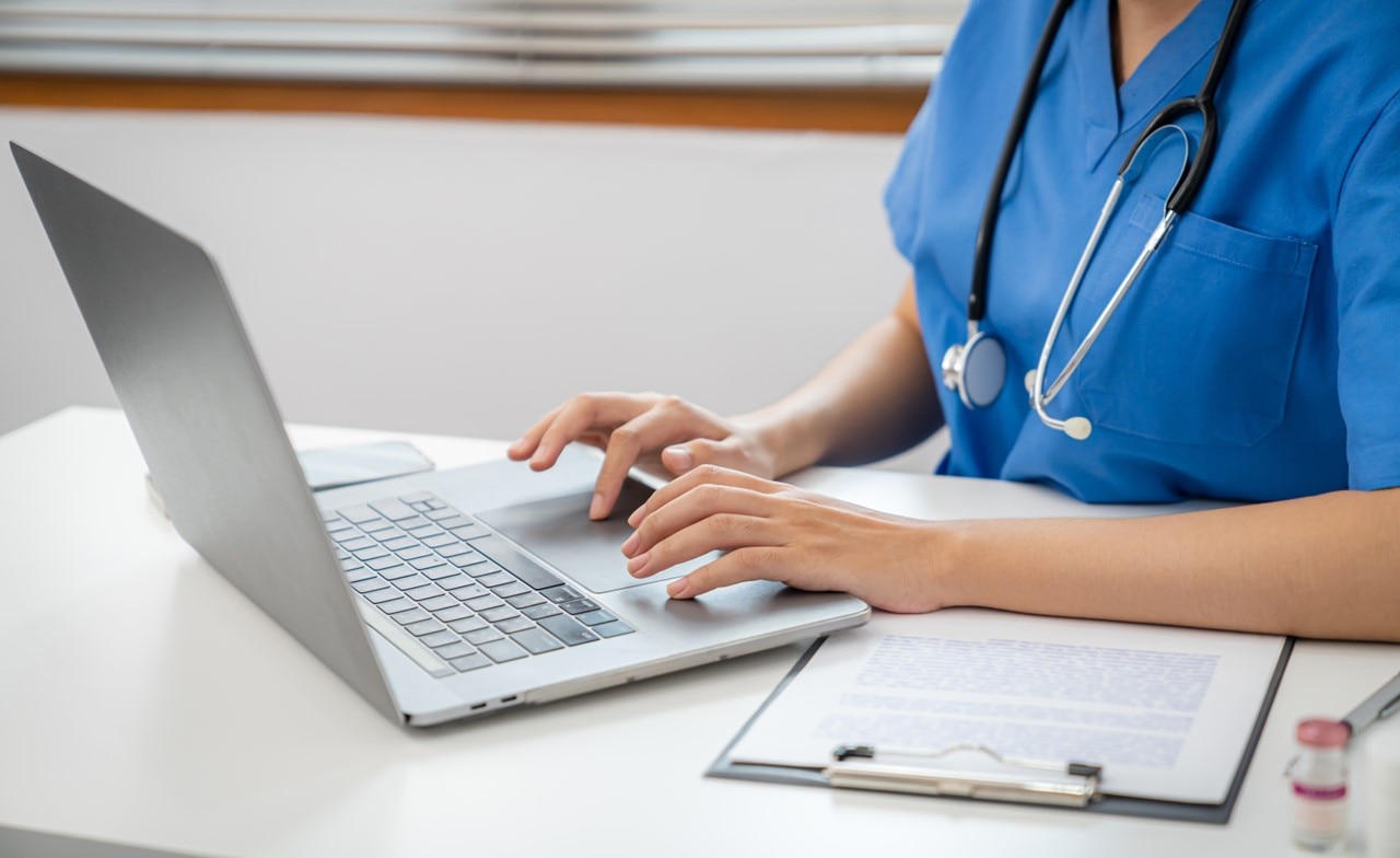 Medical professional entering data on a laptop Medical professional entering data on a laptop