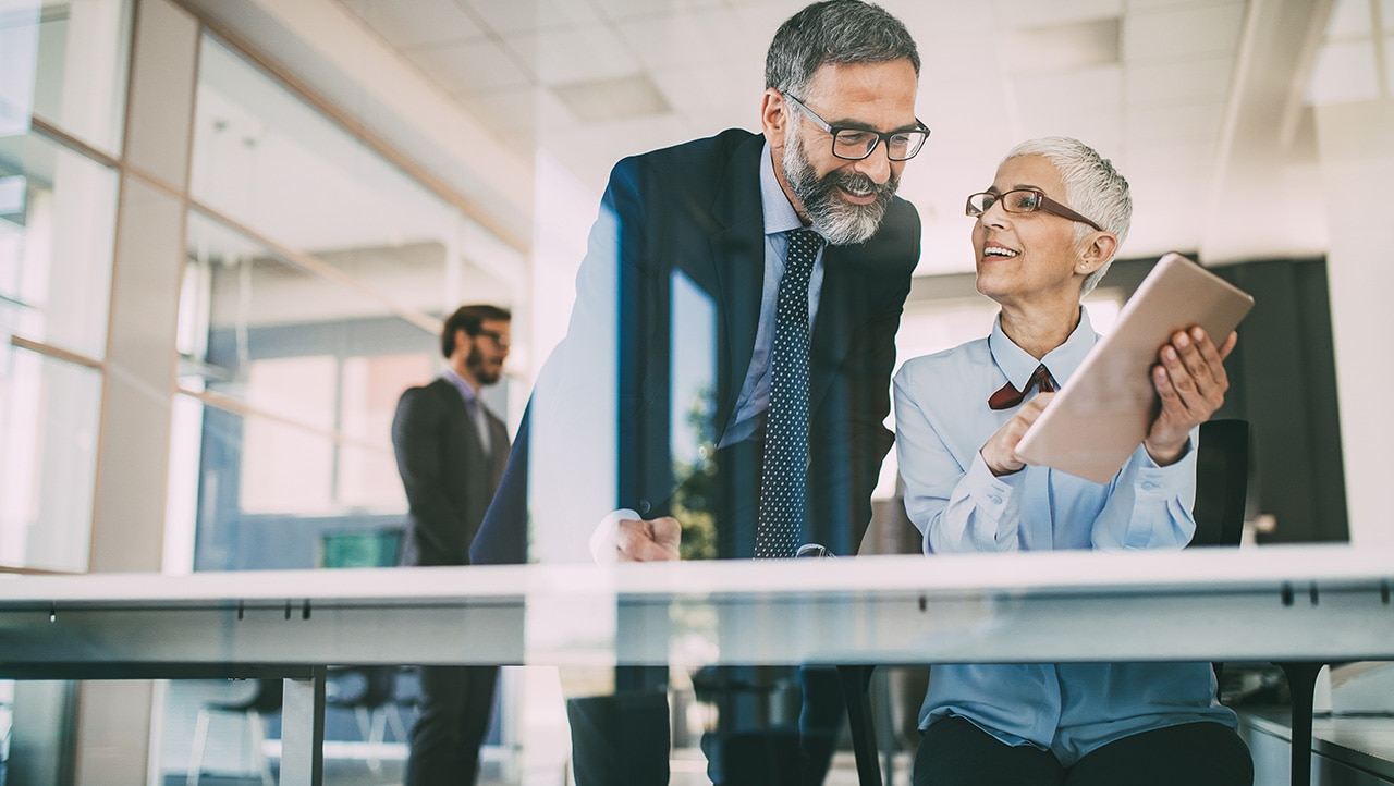 Man and women working on a computer Man and women working on a computer