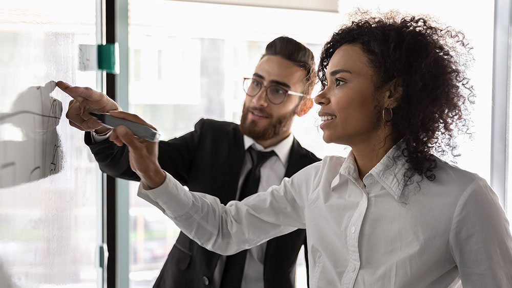 Man and woman working with a whiteboard Man and woman working with a whiteboard