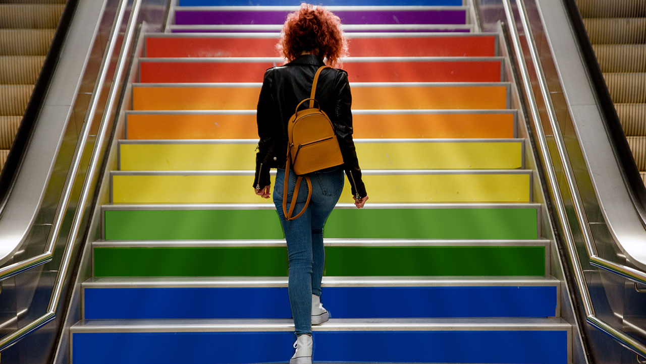 A person walking up rainbow colored steps A person walking up rainbow colored steps