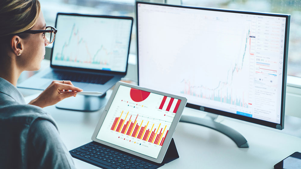 Banking trade data Business person viewing banking trade data on multiple screens