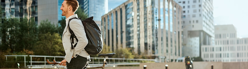 Active Travel: Smart Community Platforms Person walking alongside bicycle in cityscape