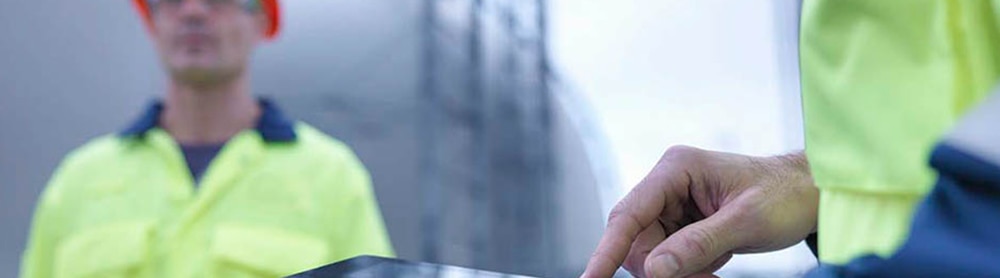 Workers looking at stats and diagrams on clipboard Workers looking at stats and diagrams on clipboard