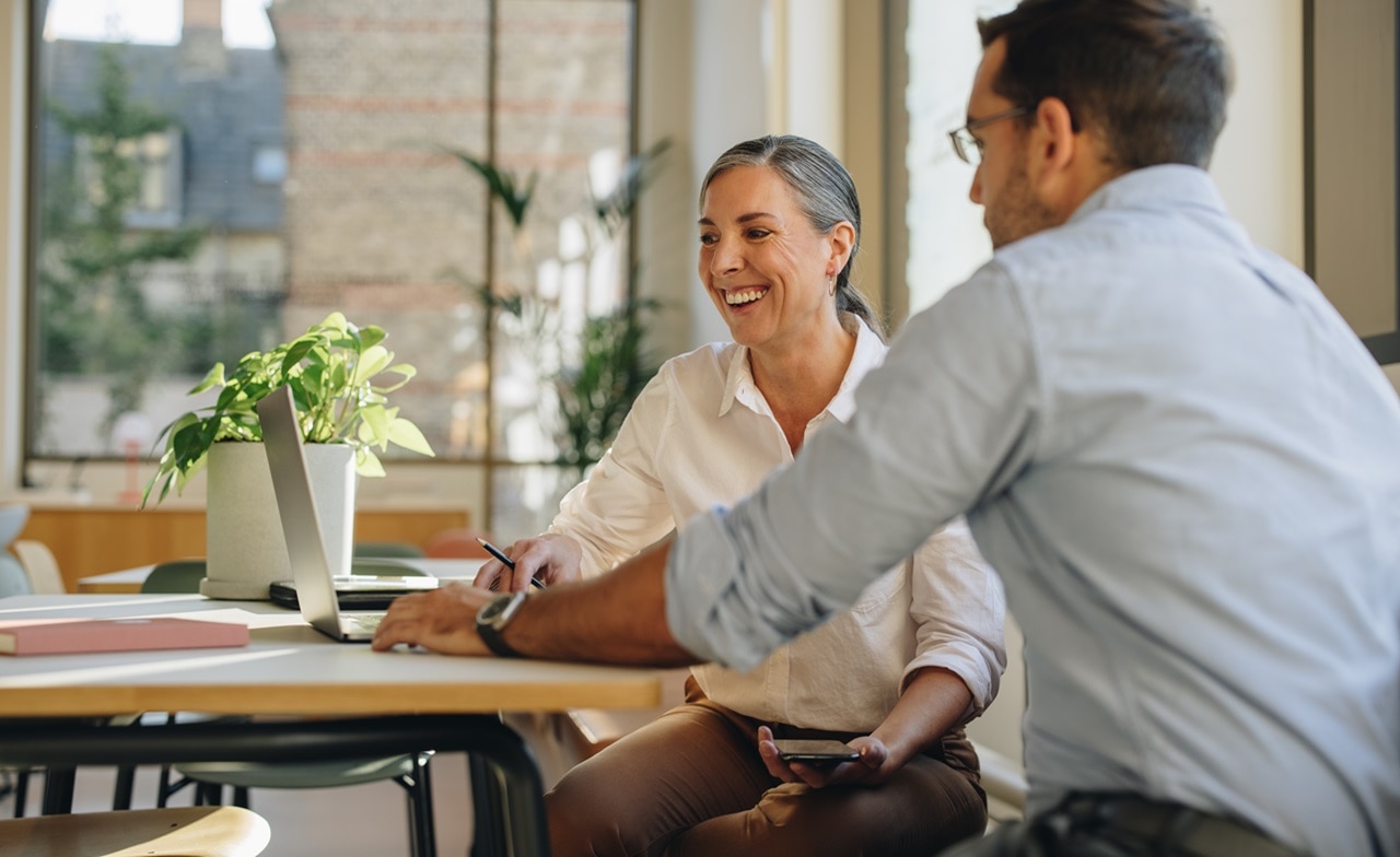 A man and a woman looking at a computer A man and a woman looking at a computer