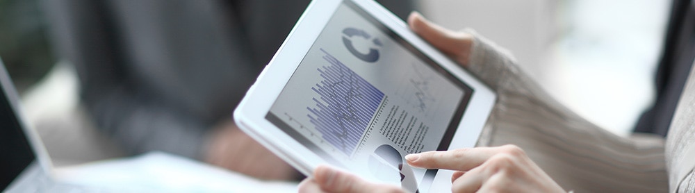 Person holding tab looking at analytics Person holding tab looking at analytics