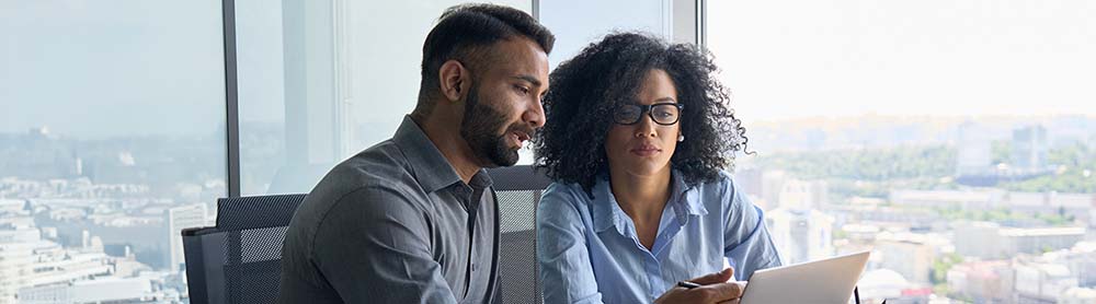 two consultants discussing information on a laptop two consultants discussing information on a laptop