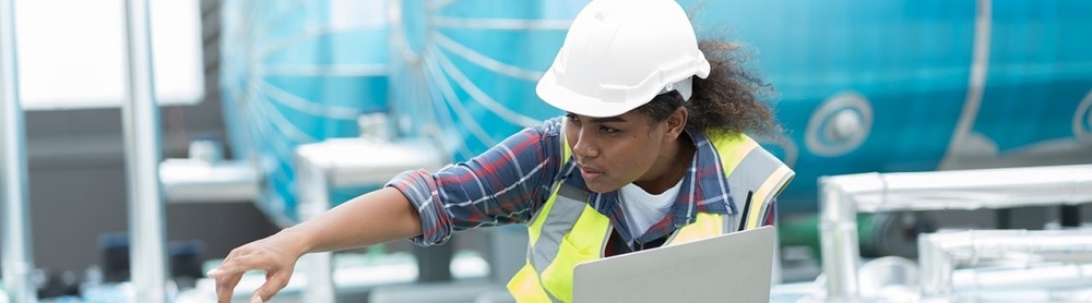 utility-worker-holding-computer-inspecting-equipment-mobile Utility worker holding a computer inspecting equipment