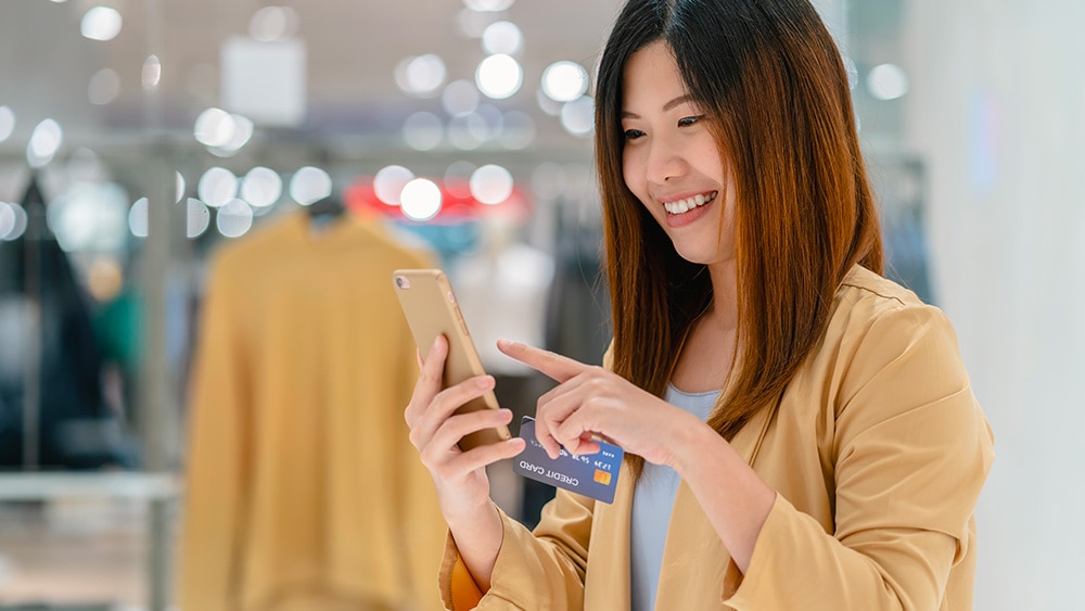 Woman with phone smiling in retail store Woman with phone smiling in retail store