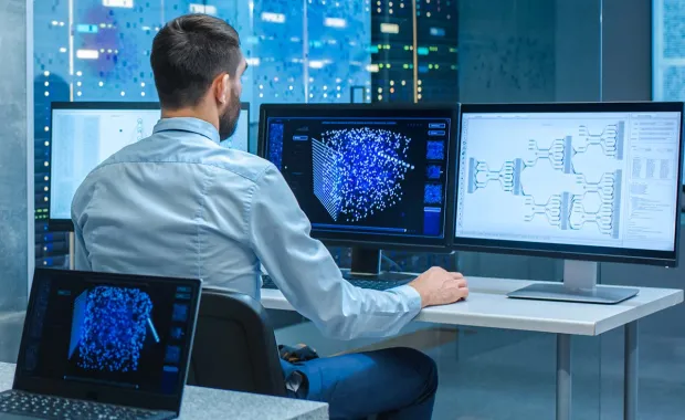 Consultant working on several computer screens