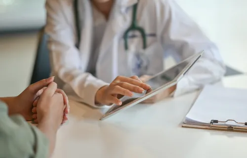 Doctor's hands showing a patient information on a tablet