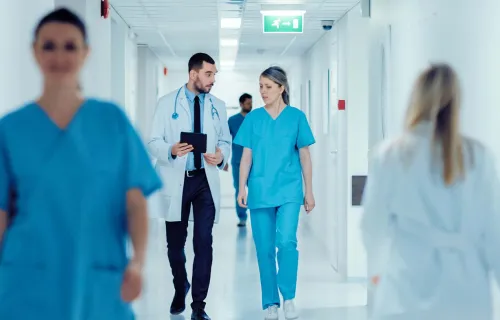 healthcare workers walking in hospital corridor