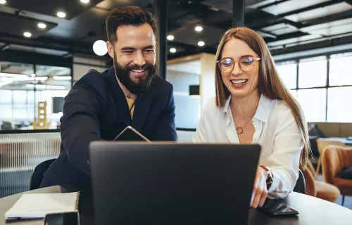 Professionals happily looking at the results on a laptop