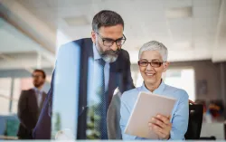 consultant and banking client looking at tablet