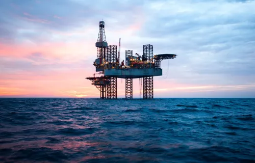 offshore platform rig on the ocean with a sunset behind