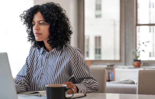 Consultant works on laptop at desk using machine learning to predict cracks in steel