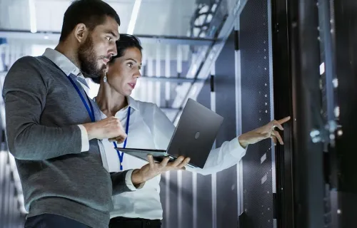 Zwei IT-Techniker stehe in einem Rechenzentrum