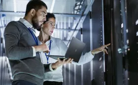 Woman and Man looking at servers in a datacenter Woman and Man looking at servers in a datacenter