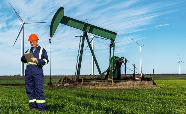 oil worker in front of onshore oil rig