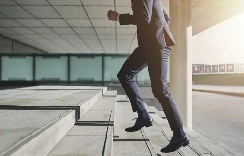 Person in a suit running up stairs