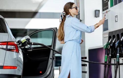 Woman filling up car at petrol station