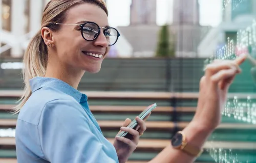 Mulher a segurar o telefone na mão e a escrever num visor digital